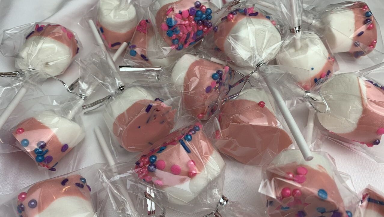 Picture of strawberry dipped marshmallows on sticks, covered in sprinkles and wrapped in cellophane.