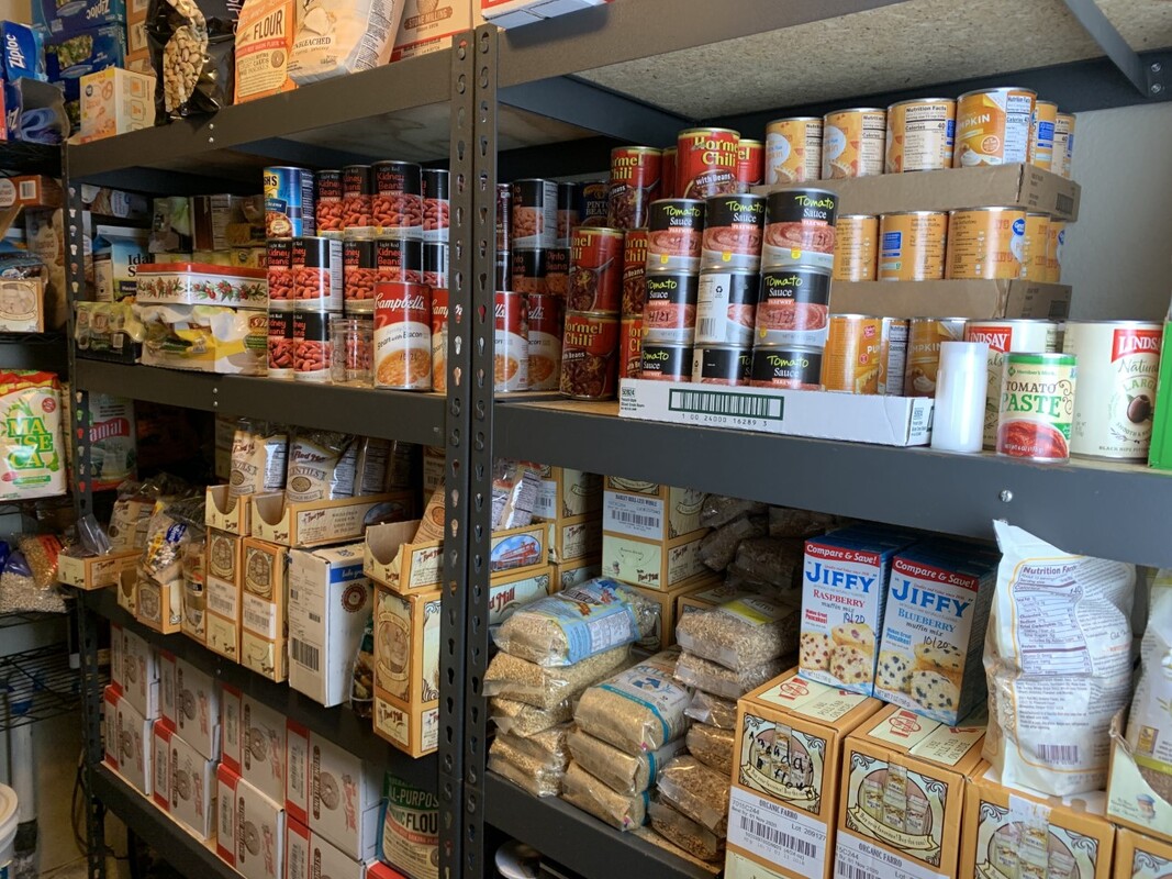 Pantry shelves lined with canned food and dried beans and grains.